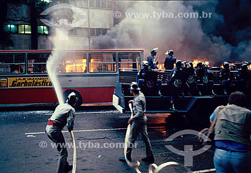  Firemen and the police anti-riot squad beside a bus on fire - Manifestation against bus fee increase - Rio de Janeiro city - Rio de Janeiro state - Brazil Date: in the 80s 