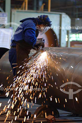  Worker cutting a steel tube, sparkles 
