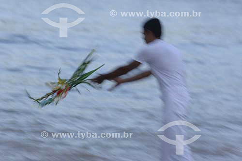  Man offering flowers - Orixas - Iemanjá cult - Umbanda and Candomble - African Brazilian religion - New Year`s Eve - Copacabana Beach - Rio de Janeiro city - Rio de Janeiro state - Brazil  - 2005 