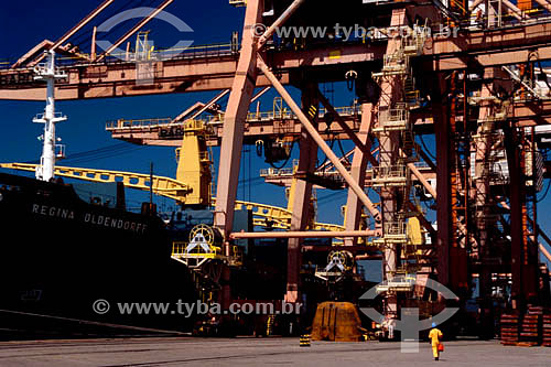 Worker walking in front of derricks and a cargo ship in Tubarao Seaport - Vitoria city - Espirito Santo state - Brazil 