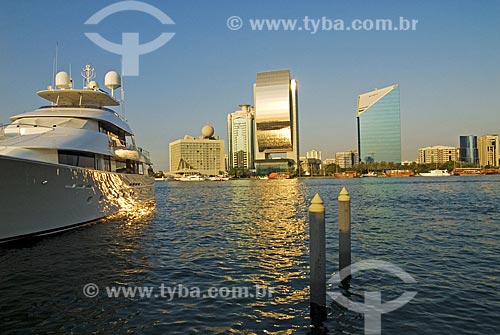  Subject: Luxury yacht and modern buildings at Creek Bay margin - building of the National Bank of Dubai in focus, reflecting its golden  / Place:  Dubai - United Arab Emirates  / Date: Janeiro 2009 