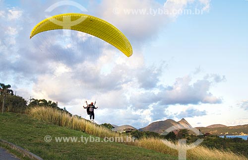  Subject: Man flying in a paraglider over a small hill between Piratininga beach and Camboinhas beach  / Place:  Niteroi city - Rio de Janeiro state - Brazil  / Date: Junho de 2009 