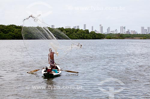  Subject: Fisherman practicing net fishing in the in the Ilha de Deus (Deus Island) with the buildings of the Boa Viagem beach in the background  / Place:  Recife - Pernambuco  / Date: 14/10/2010 