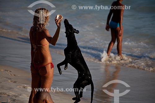  Subject: Woman playing with dog at Arpoador beach  / Place:  Ipanema neighborhood - Rio de Janeiro city - Brazil  / Date: 02/2011 