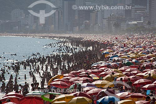  Subject: Sunshades on the beach full of people of the Arpoador with buildingd in background  / Place:  Ipanema neighborhood - Rio de Janeiro city - Brazil  / Date: 01/2011 