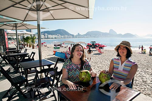  Subject: Friends talking and drinking coconut water kiosk at the edge of Copacabana beach - DC nº 89 e nº 90 / Place: Copacabana - Rio de Janeiro city - Rio de Janeiro state - Brazil  / Date: 04/2011 