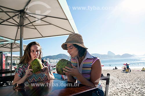  Subject: Friends talking and drinking coconut water kiosk at the edge of Copacabana beach - DC nº 89 e nº 90 / Place: Rio de Janeiro city - Rio de Janeiro state (RJ) - Brazil / Date: 04/2011 