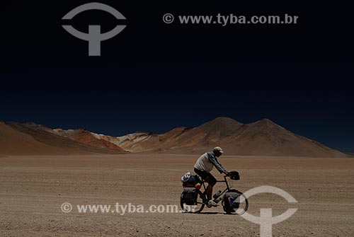  Subject: Tourist riding a bicycle with Seven Colors of the Mountain in the background / Place: Bolivia - South America / Date: 01/2011 