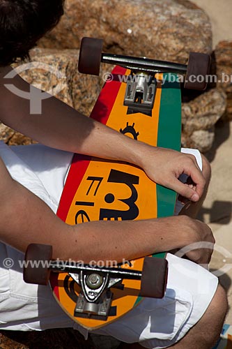  Subject: Man sitting holding the skate on Ipanema beach / Place: Ipanema neighborhood - Rio de Janeiro city - Rio de Janeiro state (RJ) - Brazil / Date: 04/2012 