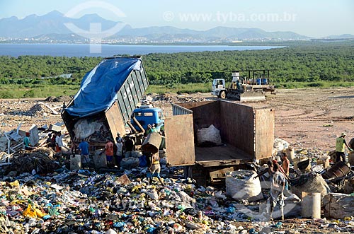  Workers waiting unloading garbage truck while others loading a truck with bags of selective collection at the Jardim Gramacho sanitary landfill, in the background the city of Rio de Janeiro  - Duque de Caxias city - Rio de Janeiro state (RJ) - Brazil