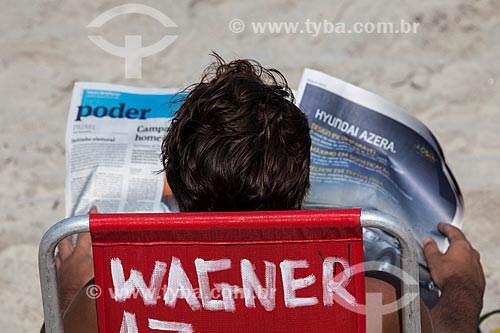  Subject: Man reading newspaper on chair rental for use by bathers / Place: Ipanema neighborhood - Rio de Janeiro city - Rio de Janeiro state (RJ) - Brazil / Date: 05/2013 