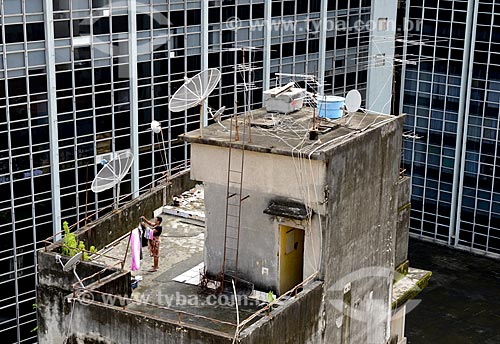  Subject: Woman extending clothes on the terrace of a residential building between commercial buildings / Place: City center neighborhood - Rio de Janeiro city - Rio de Janeiro state (RJ) - Brazil / Date: 02/2013 