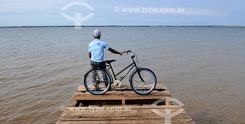  Subject: Man leaning on his bike looking the Tiete River / Place: Pereira Barreto city - Sao Paulo state (SP) - Brazil / Date: 10/2013 