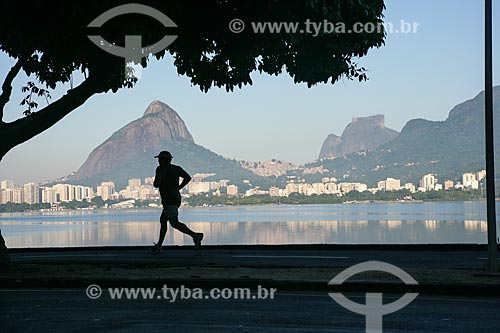  Man running at bike lane of Rodrigo de Freitas Lagoon with Two Brothers Mountain and Rock of Gavea in the background  - Rio de Janeiro city - Rio de Janeiro state (RJ) - Brazil