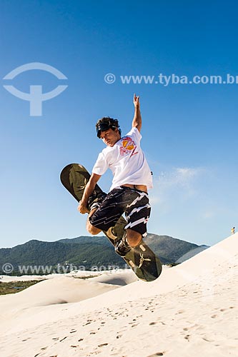  Man practicing sandboarding in the dunes of Joaquina Beach  - Florianopolis city - Brazil