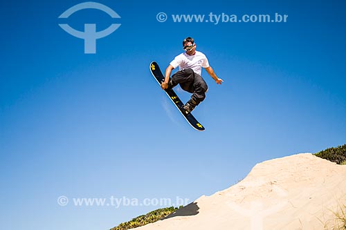  Man practicing sandboarding in the dunes of Praia Grande Beach  - Sao Francisco do Sul city - Brazil