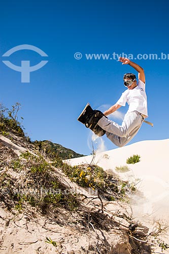  Man practicing sandboarding in the dunes of Santinho Beach  - Florianopolis city - Brazil