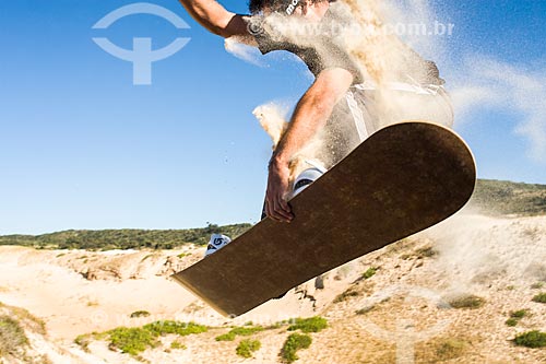  Man practicing sandboarding in the dunes of Ribanceira Beach  - Imbituba city - Brazil
