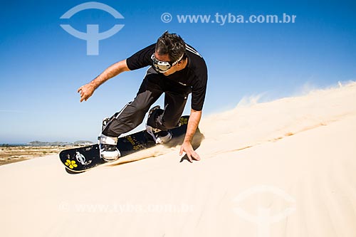  Man practicing sandboarding in the dunes of Itapiruba Beach  - Imbituba city - Brazil