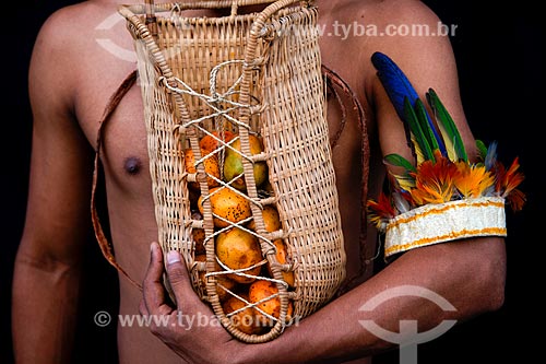  Subject: Indian of ticuna tribe holding straw basket with mari (Geoffroea spinosa) / Place: Amazonas state (AM) - Brazil / Date: 01/2014 