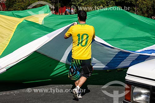  Subject: Man opening the brazilian flag near to Corinthians Arena / Place: Itaquera neighborhood - Sao Paulo city - Sao Paulo state (SP) - Brazil / Date: 06/2014 