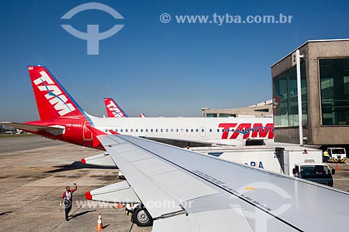  Detail of airplane wing with airplanes of TAM Airlines in the background - Congonhas Airport (1936)  - Sao Paulo city - Sao Paulo state (SP) - Brazil
