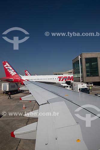  Detail of airplane wing with airplanes of TAM Airlines in the background - Congonhas Airport (1936)  - Sao Paulo city - Sao Paulo state (SP) - Brazil