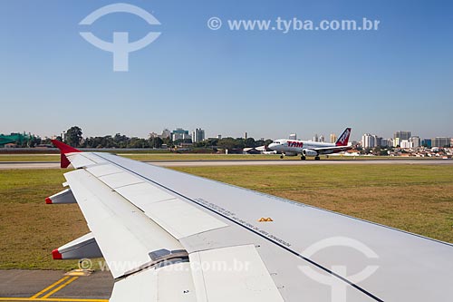  Detail of airplane wing with airplane of TAM Airlines in the background - Congonhas Airport (1936)  - Sao Paulo city - Sao Paulo state (SP) - Brazil