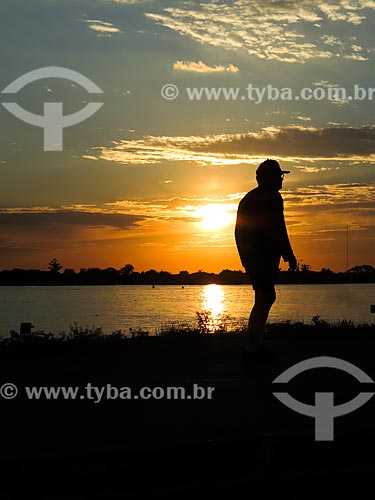  Man walking on the banks of Guaiba Lake during sunset  - Porto Alegre city - Rio Grande do Sul state (RS) - Brazil