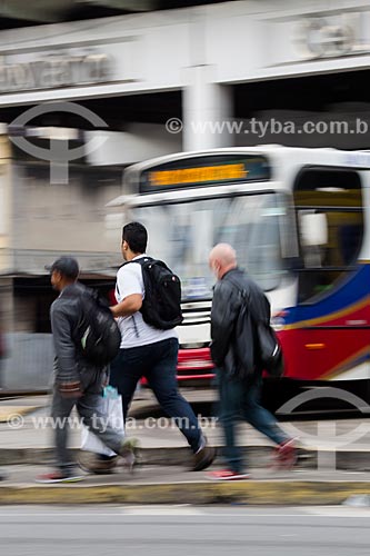  Men passing opposite of the bus in Bus Terminal Coronel Americo Fontenelle   - Rio de Janeiro city - Rio de Janeiro state (RJ) - Brazil