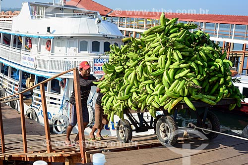  Men unloading wheelbarrow with bananas in port on the banks of Tapajos River  - Itaituba city - Para state (PA) - Brazil