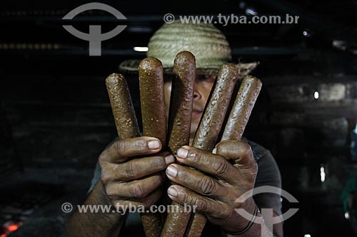  Riverine holding Bastoes de Guarana (Guarana Sticks) - typical product from Maues region  - Maues city - Amazonas state (AM) - Brazil