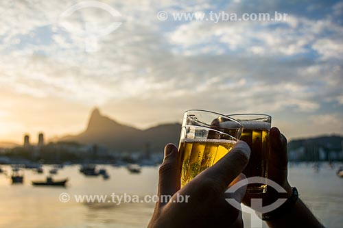  Toast beer at sunset on Urca wall - Corcovado Mountain in the background  - Rio de Janeiro city - Rio de Janeiro state (RJ) - Brazil