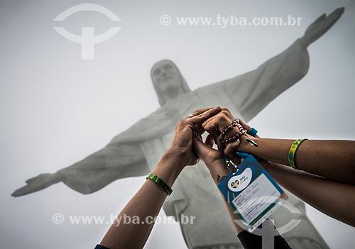  Detail of hands joined in prayer with Christ the Redeemer in the background during World Youth Day (WYD)  - Rio de Janeiro city - Rio de Janeiro state (RJ) - Brazil