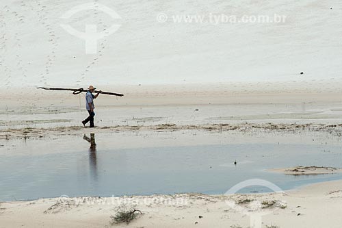  Man walking on the banks of small lagoon - Lencois Maranhenses National Park  - Barreirinhas city - Maranhao state (MA) - Brazil