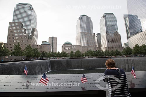  Woman praying - National September 11 Memorial (Ground Zero of the World Trade Center) with the WTC 1 in the background  - New York city - New York - United States of America