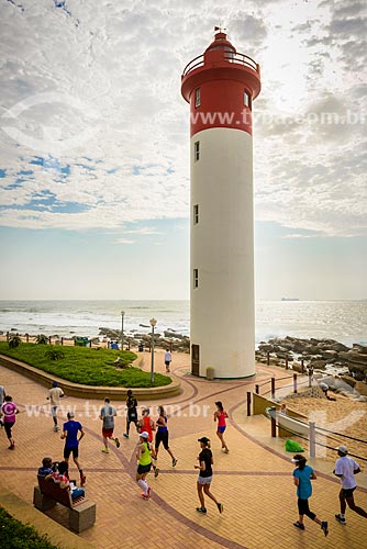  People running on the boardwalk - uMhlanga Beach with the Lighthouse in the background  - Durban city - KwaZulu-Natal province - South Africa