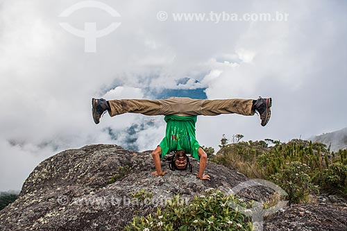  Man doing acrobatics  - Top of Morro da Cruz (Hill of the Cross) - Serra dos Orgaos National Park  - Teresopolis city - Rio de Janeiro state (RJ) - Brazil