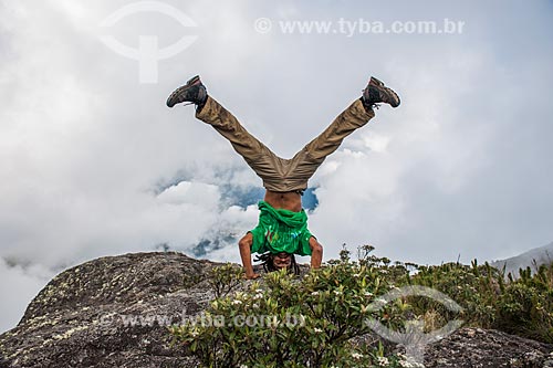  Man doing acrobatics  - Top of Morro da Cruz (Hill of the Cross) - Serra dos Orgaos National Park  - Teresopolis city - Rio de Janeiro state (RJ) - Brazil