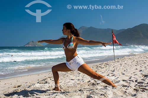  Woman practicing Yoga - Grumari Beach - virabhadrasana B movement (warrior II)  - Rio de Janeiro city - Rio de Janeiro state (RJ) - Brazil