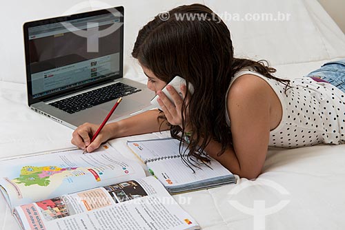  Girl studying with book, computer and cell phone  - Rio de Janeiro city - Rio de Janeiro state (RJ) - Brazil