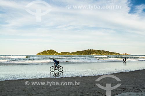  Cyclist - Campeche Beach waterfront with the Campeche Island in the background  - Florianopolis city - Santa Catarina state (SC) - Brazil