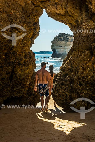  Couple passing between the crevice of rock - Alvor Beach  - Portimao municipality - Faro district - Portugal