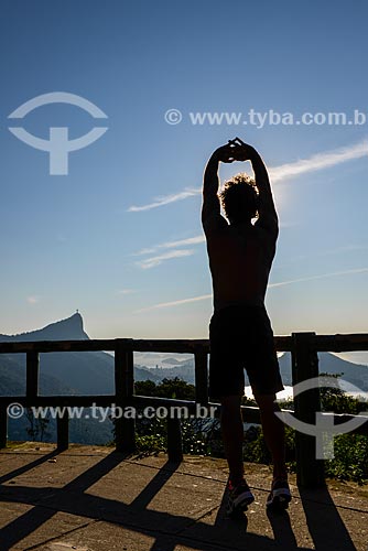  Man stretching - Vista Chinesa (Chinese View) - Tijuca National Park - with the Christ the Redeemer in the background  - Rio de Janeiro city - Rio de Janeiro state (RJ) - Brazil