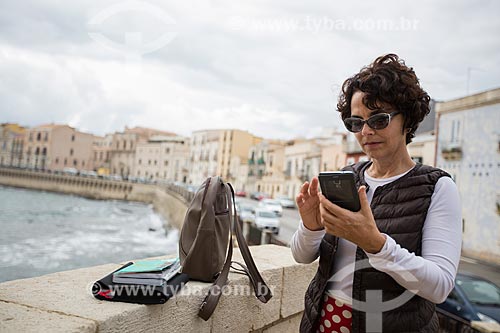  Woman using smartphone - Ortigia Island (Ortygia) - on the banks of the Ionian sea  - Syracuse - Syracuse province - Italy