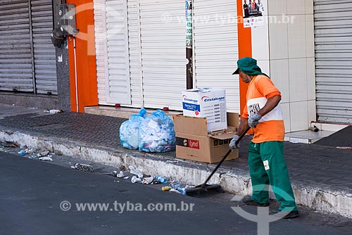  Man sweeping trash and dirt left in the street after the close of trade  - Juazeiro do Norte city - Ceara state (CE) - Brazil