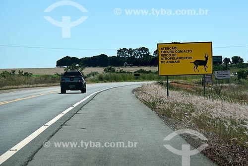  Car traveling on the GO-118 Highway with signaling plate calling attention to the high risk of running over wild animals  - Planaltina city - Goias state (GO) - Brazil