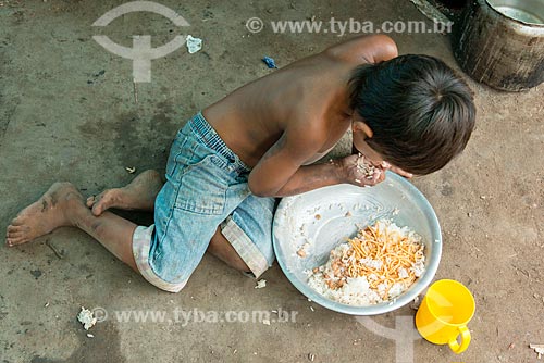  Child eating with the hand - courtyard of the Moikarako Tribe - Kayapo Indigenous Land  - Sao Felix do Xingu city - Para state (PA) - Brazil