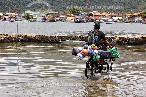  Man cycling during high tide  - Paraty city - Rio de Janeiro state (RJ) - Brazil