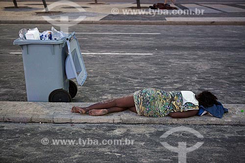  Woman sleeping - sidewalk of bike lane of the Copacabana Beach - post 6 - after the Reveillon party  - Rio de Janeiro city - Rio de Janeiro state (RJ) - Brazil